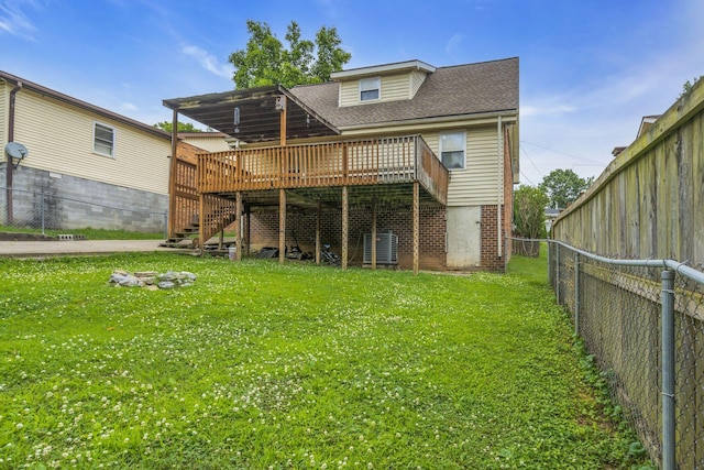 rear view of property featuring a lawn and a deck