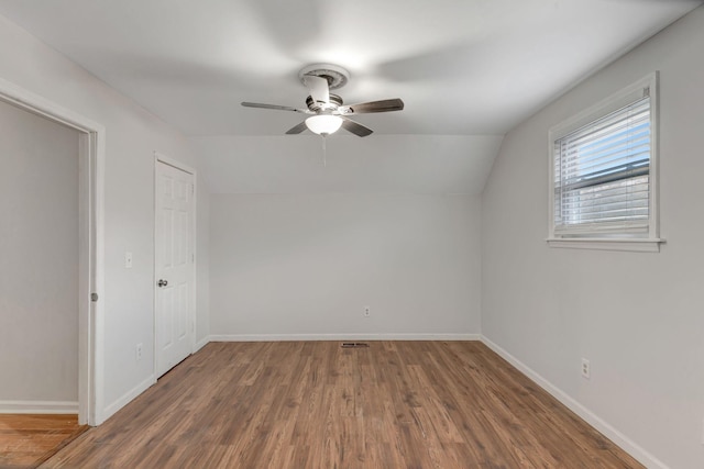 unfurnished room featuring ceiling fan, dark hardwood / wood-style flooring, and lofted ceiling