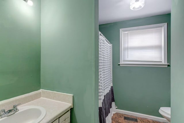 bathroom with vanity, toilet, and walk in shower