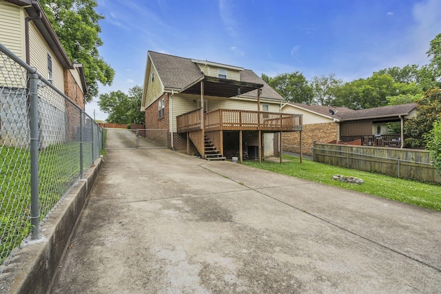 rear view of property featuring a yard and a wooden deck