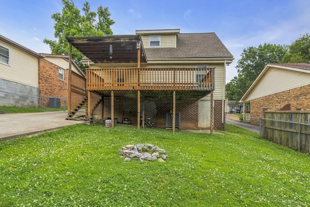 rear view of house featuring a lawn and a wooden deck