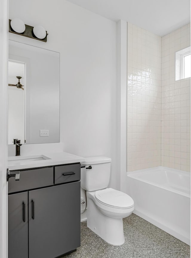 full bathroom with vanity, tiled shower / bath combo, and toilet