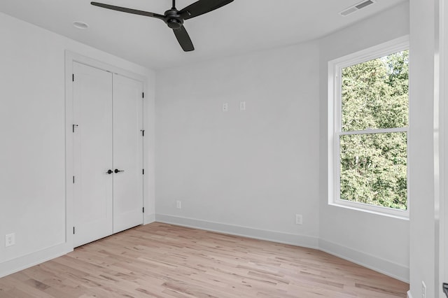 unfurnished bedroom with multiple windows, ceiling fan, and light hardwood / wood-style flooring