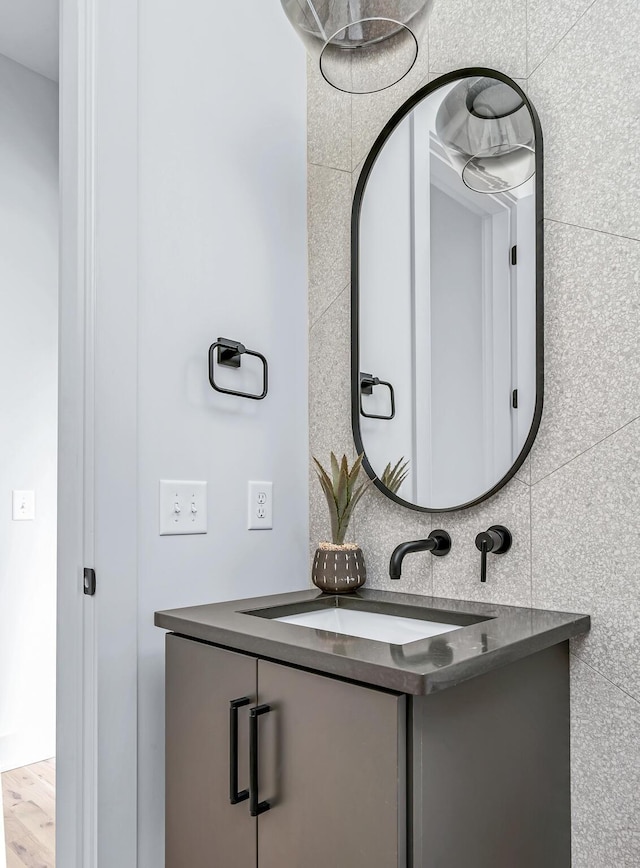 bathroom with tasteful backsplash, vanity, and tile walls