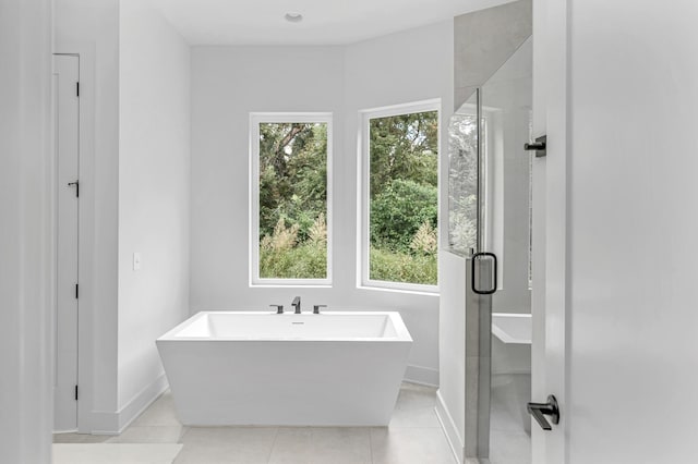 bathroom with plenty of natural light, plus walk in shower, and tile patterned flooring