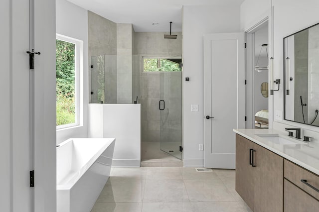 bathroom featuring tile patterned flooring, vanity, and separate shower and tub