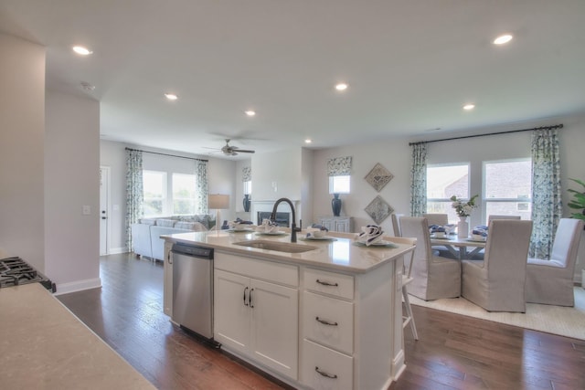 kitchen featuring white cabinets, sink, stainless steel dishwasher, dark hardwood / wood-style floors, and an island with sink