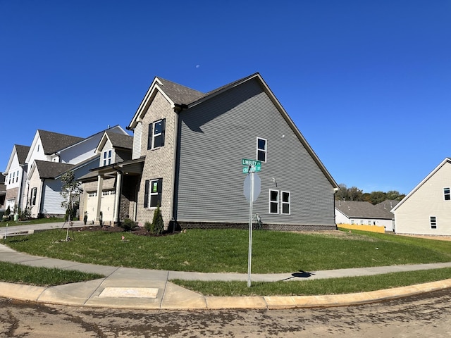 view of side of property with a lawn and a garage