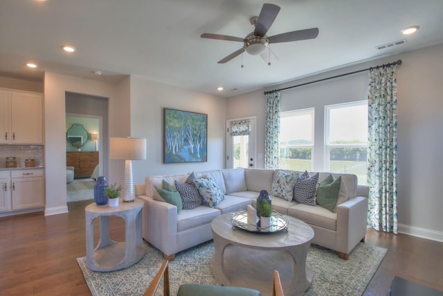 living room with ceiling fan and dark wood-type flooring