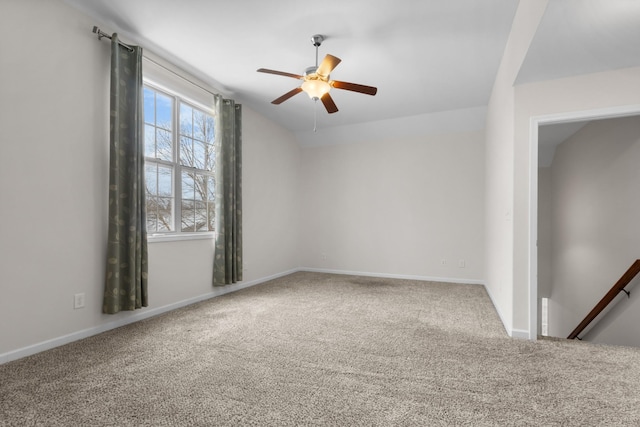 empty room with vaulted ceiling, carpet, and ceiling fan