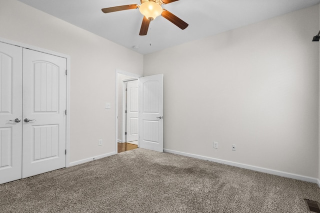 unfurnished bedroom featuring carpet, ceiling fan, and a closet