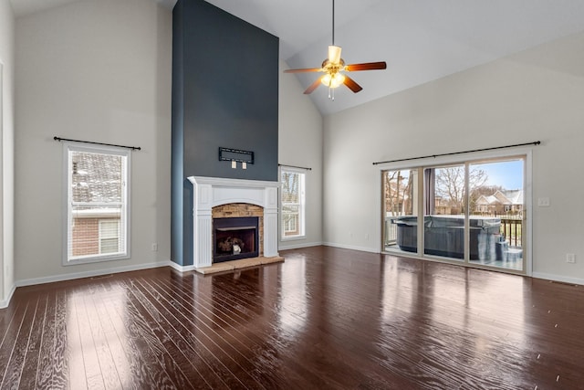 unfurnished living room with ceiling fan, wood-type flooring, a fireplace, and high vaulted ceiling