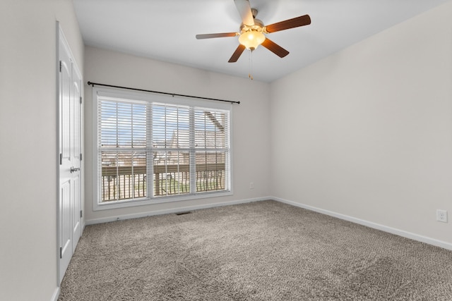 carpeted spare room featuring ceiling fan