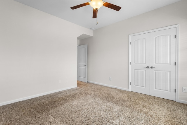 unfurnished bedroom featuring ceiling fan, carpet flooring, and a closet