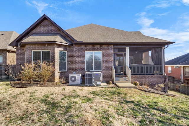 back of property with a sunroom, cooling unit, ac unit, and a lawn