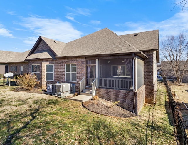 back of house featuring a lawn, a sunroom, and central air condition unit