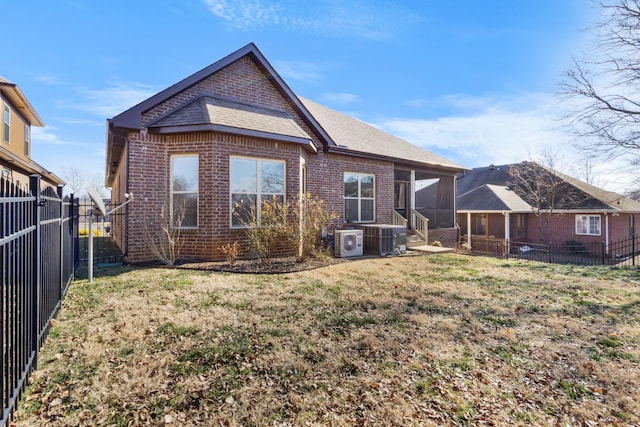 back of property with a yard, central AC unit, a sunroom, and ac unit