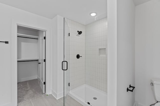 bathroom with tile patterned flooring, toilet, and walk in shower