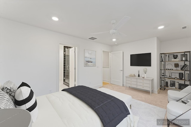 bedroom featuring ceiling fan, ensuite bathroom, and light colored carpet