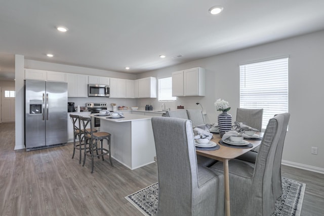 dining space with sink and light wood-type flooring