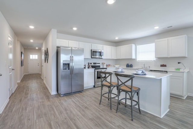 kitchen with white cabinetry, sink, a kitchen island, and appliances with stainless steel finishes