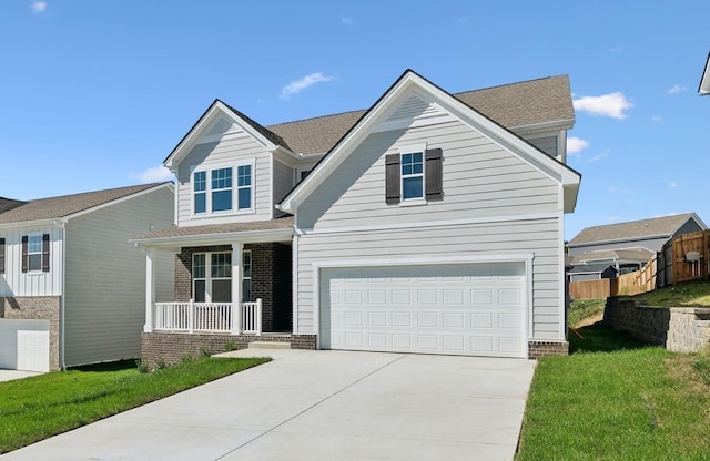 view of front of property with covered porch, a garage, and a front lawn