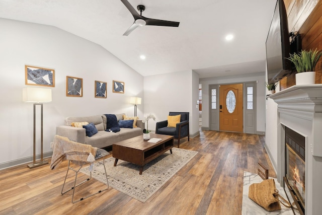 living room featuring ceiling fan, hardwood / wood-style floors, and lofted ceiling