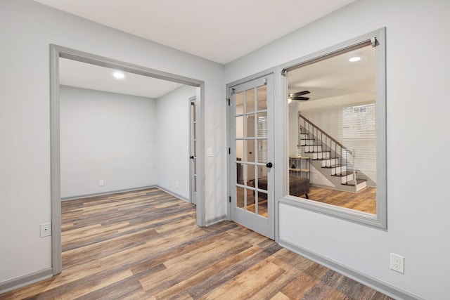 unfurnished room featuring hardwood / wood-style flooring, ceiling fan, and french doors