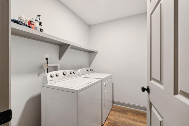 clothes washing area featuring washer and dryer and wood-type flooring