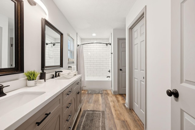 bathroom featuring shower / bath combination with curtain, wood-type flooring, and vanity