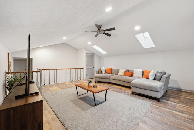 living room featuring a textured ceiling, ceiling fan, hardwood / wood-style floors, and lofted ceiling