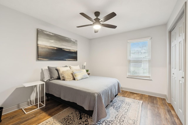 bedroom featuring ceiling fan, dark hardwood / wood-style flooring, and a closet