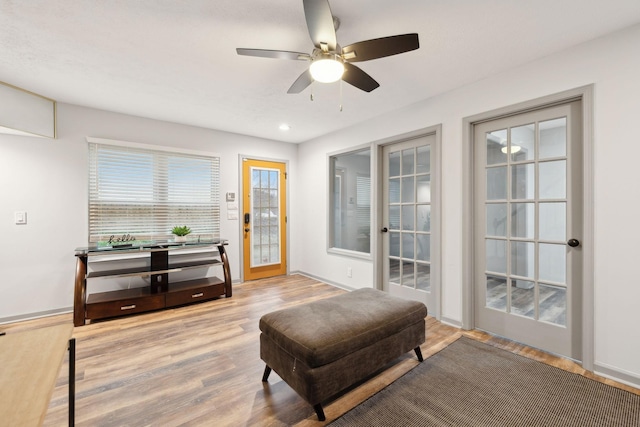 sitting room featuring french doors, hardwood / wood-style flooring, and ceiling fan