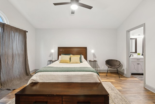 bedroom with light hardwood / wood-style flooring, ensuite bath, ceiling fan, and lofted ceiling