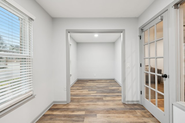 hall with wood-type flooring and french doors