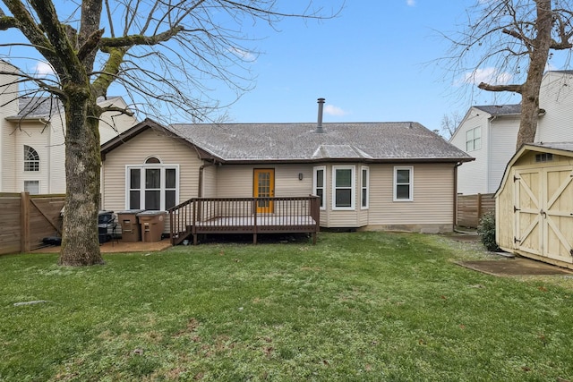 back of house with a lawn, a storage shed, and a deck