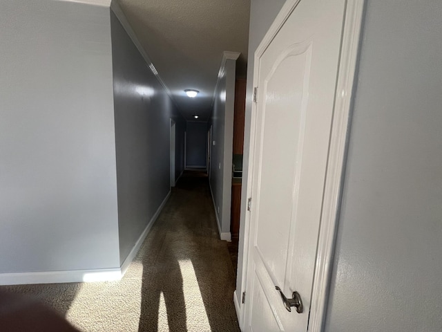 corridor featuring a textured ceiling and crown molding