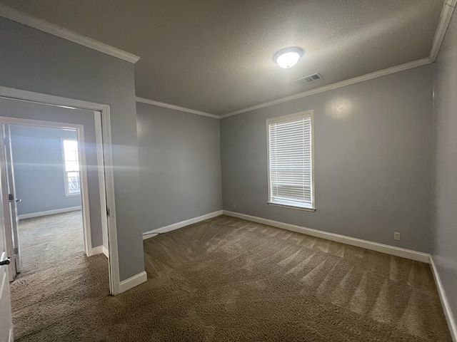 carpeted spare room featuring ornamental molding and a textured ceiling