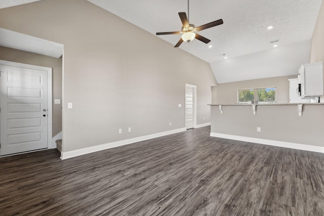 unfurnished living room with ceiling fan, dark wood-type flooring, and high vaulted ceiling