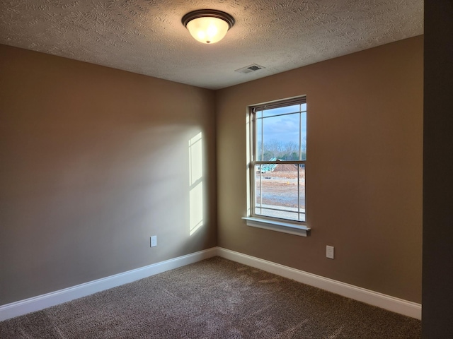 empty room with carpet flooring and a textured ceiling