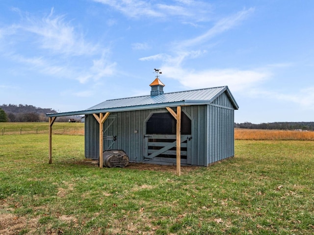 view of outdoor structure featuring a yard and a rural view