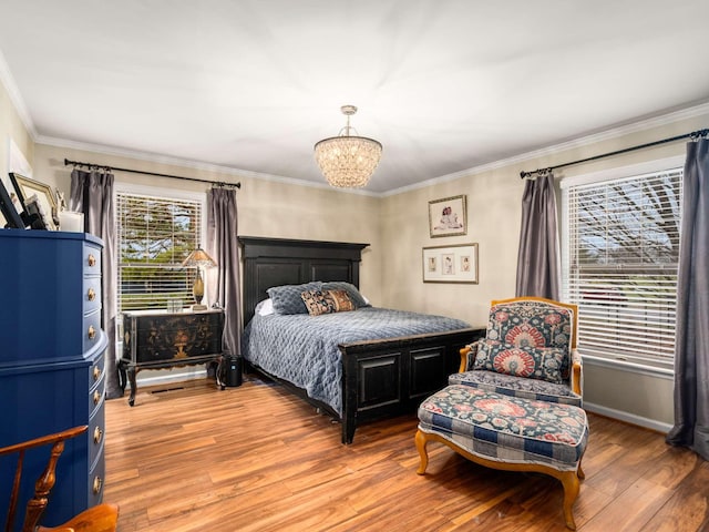 bedroom featuring hardwood / wood-style floors, an inviting chandelier, and ornamental molding