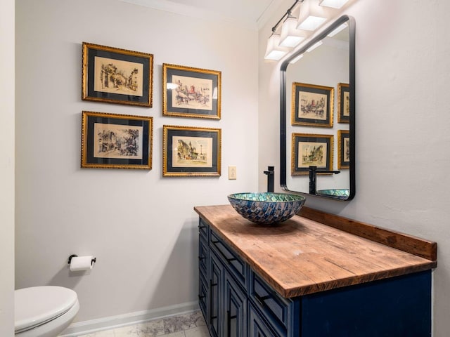 bathroom with vanity, toilet, and crown molding