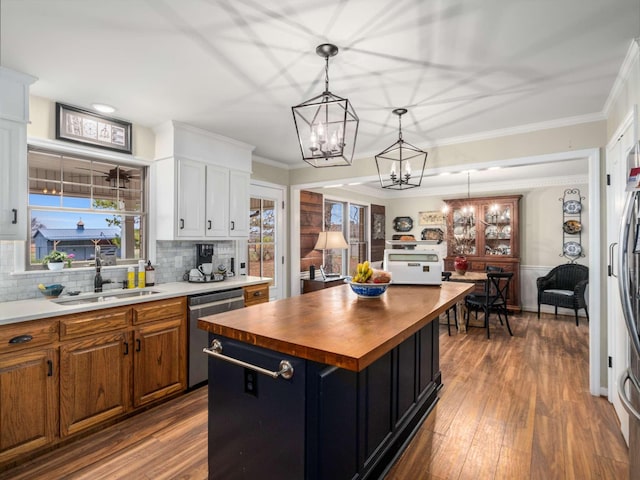 kitchen with wooden counters, crown molding, sink, dishwasher, and a center island