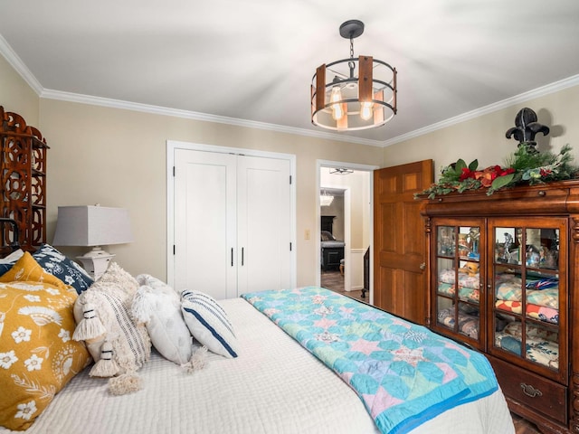 bedroom with a closet, an inviting chandelier, and ornamental molding