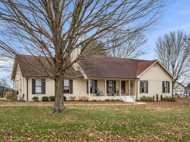 ranch-style house featuring covered porch and a front yard