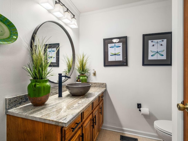 bathroom featuring tile patterned flooring, vanity, toilet, and crown molding