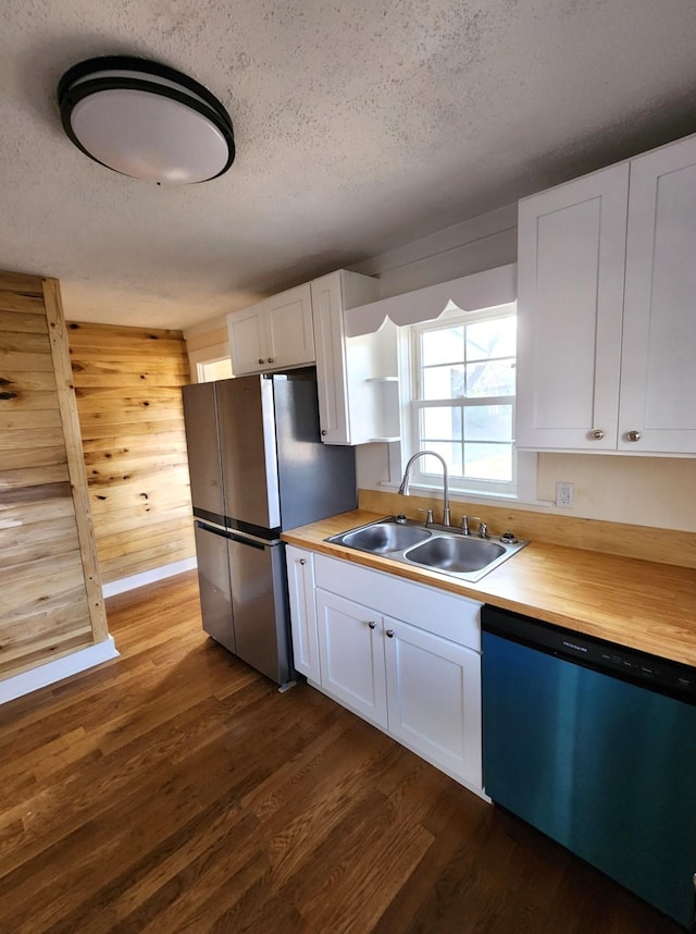 kitchen featuring a textured ceiling, stainless steel appliances, white cabinetry, and sink