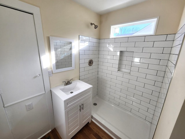 bathroom with tiled shower, wood-type flooring, and vanity