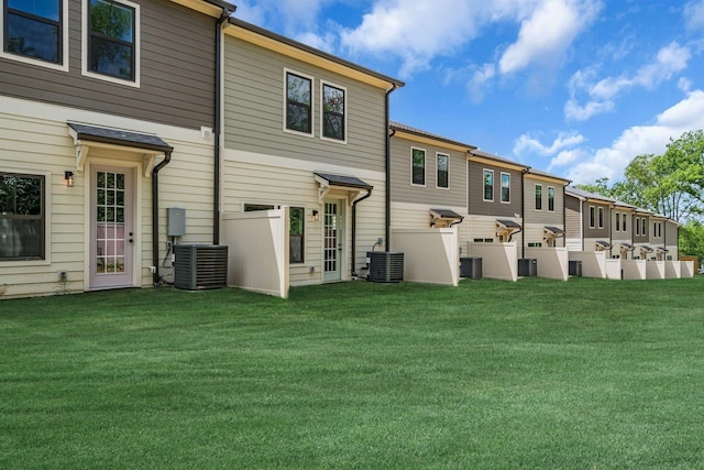 back of property with cooling unit and a lawn